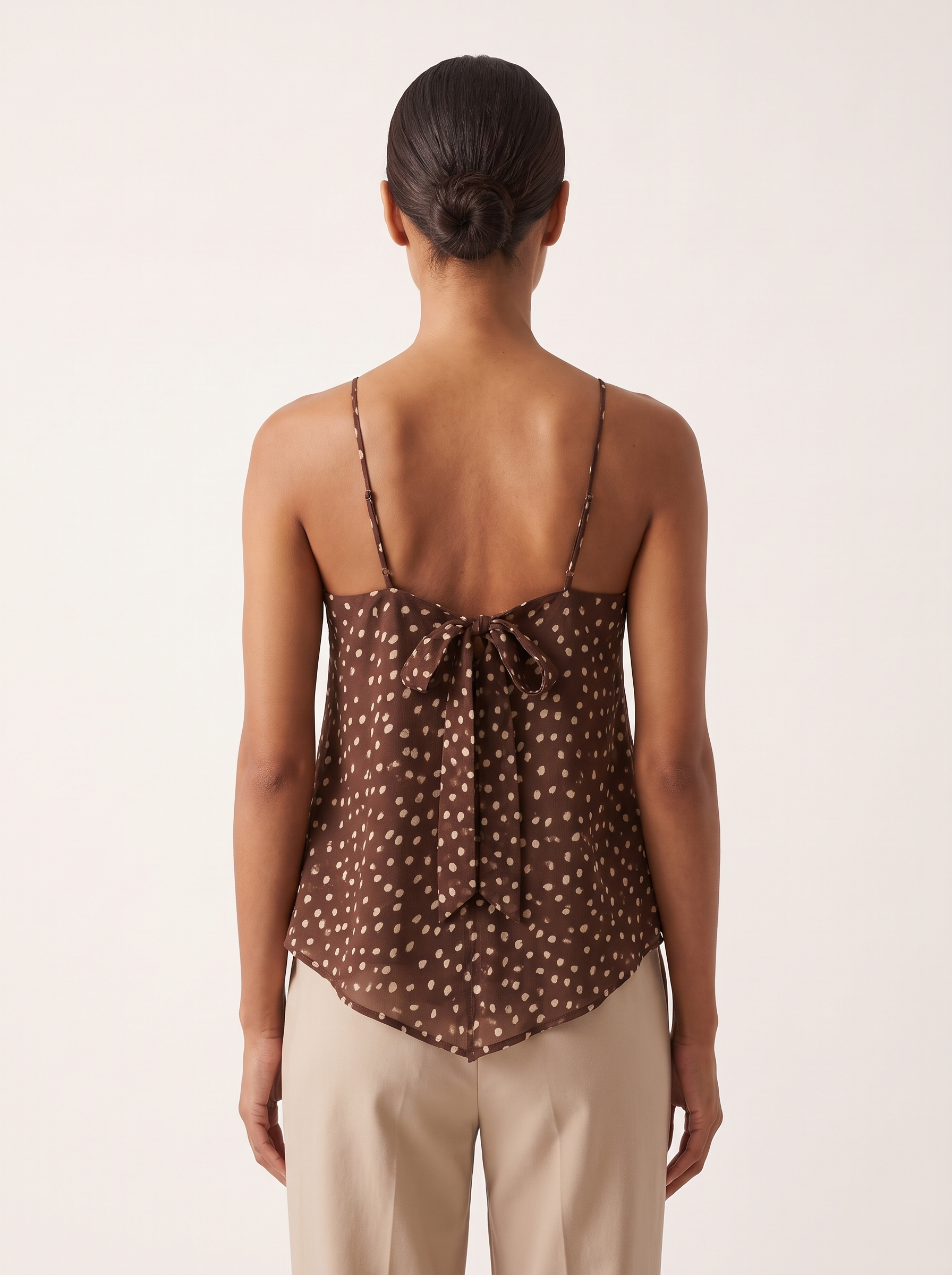Polka Dot Chiffon Cami with Tie Back and Asymmetric Hem — full-length studio back view on a warm ivory seamless background