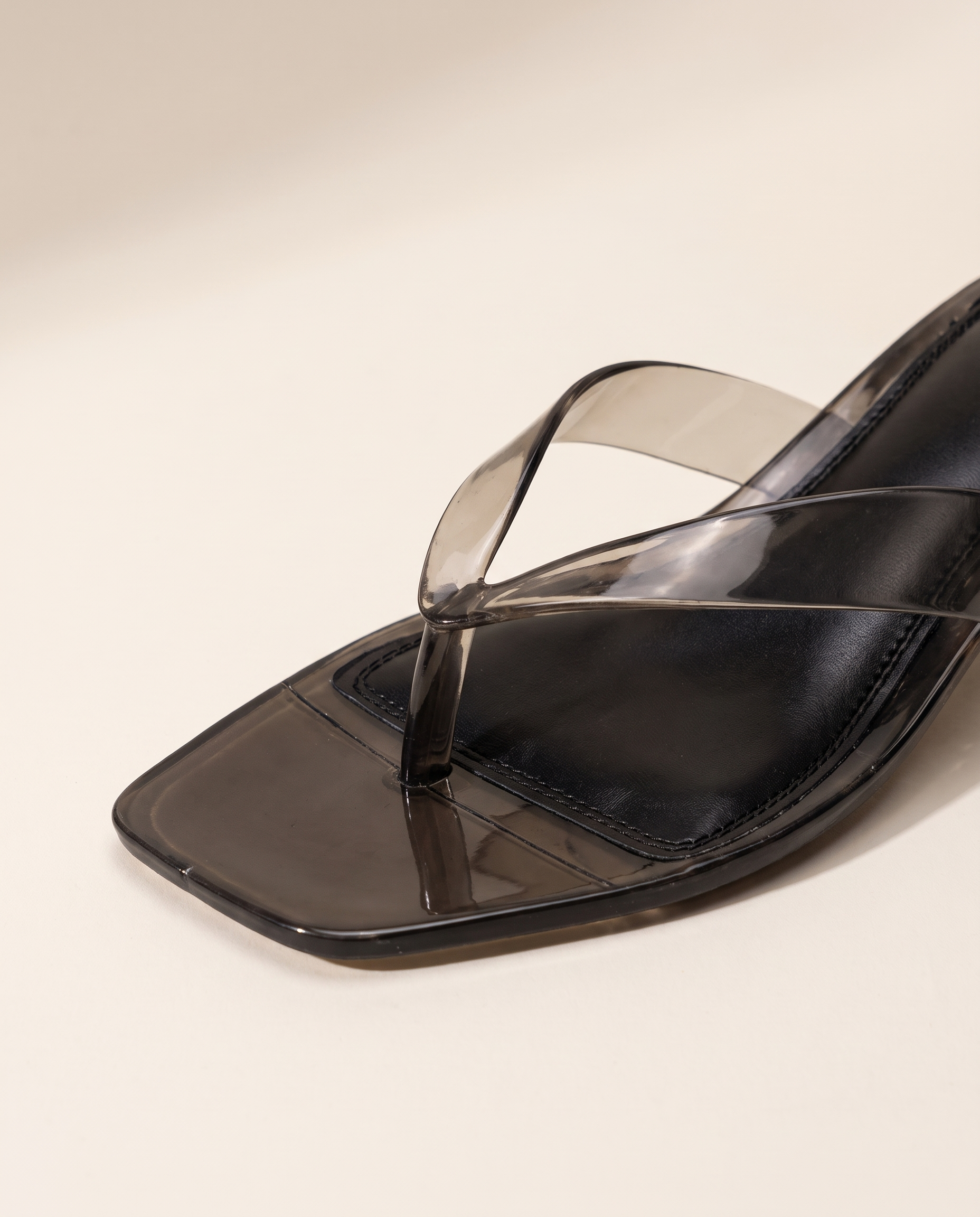 Close-up of the translucent black thong straps and square toe